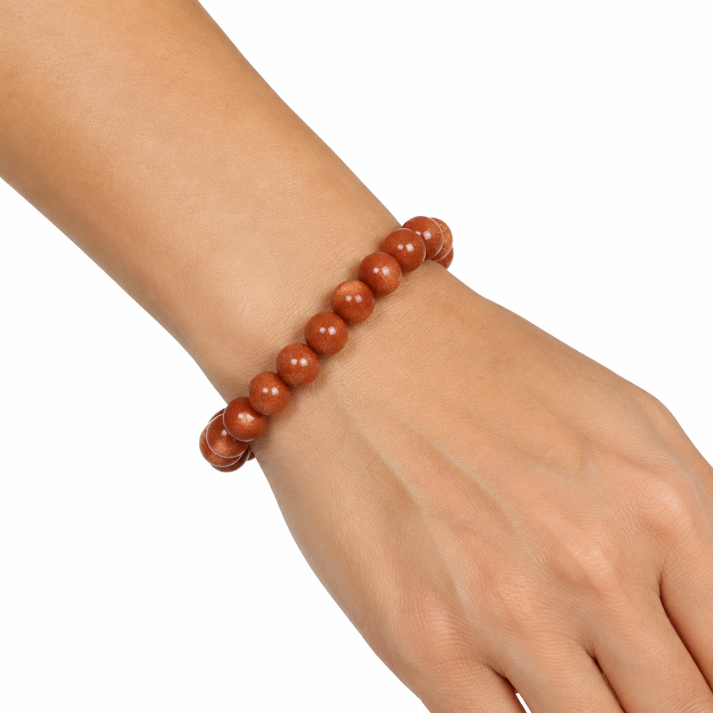 Bransoletka Golden Sand Stone na nadgarstku modelki, biale tlo